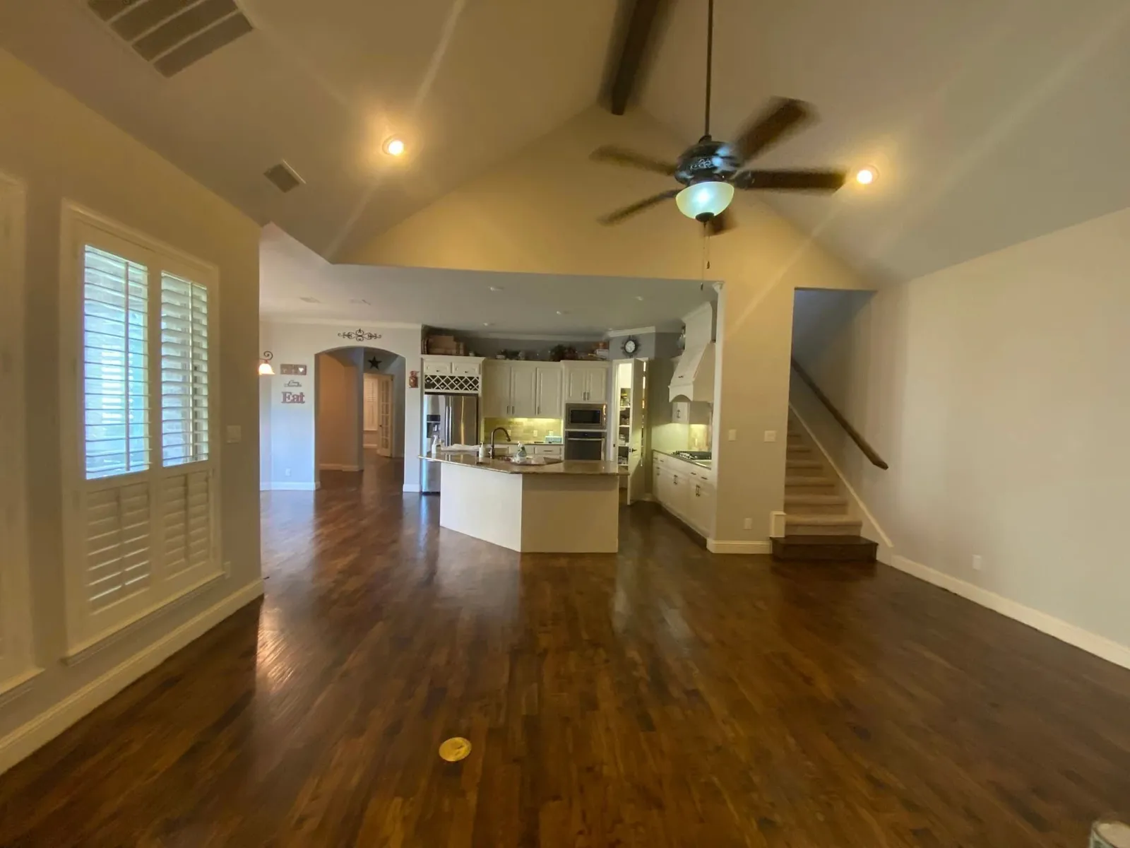 Hardwood flooring running continuously through an open-plan living room and kitchen in a Dallas Fort Worth, TX home